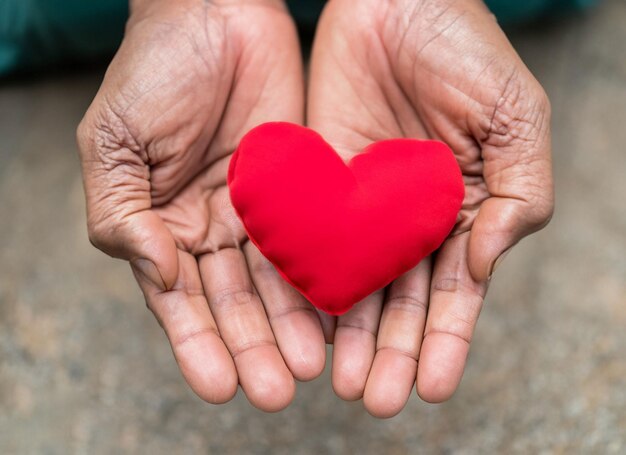 Mains tenant un coeur rouge