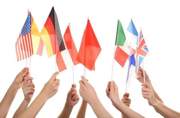 Mains tenant différents drapeaux isolés sur blanc