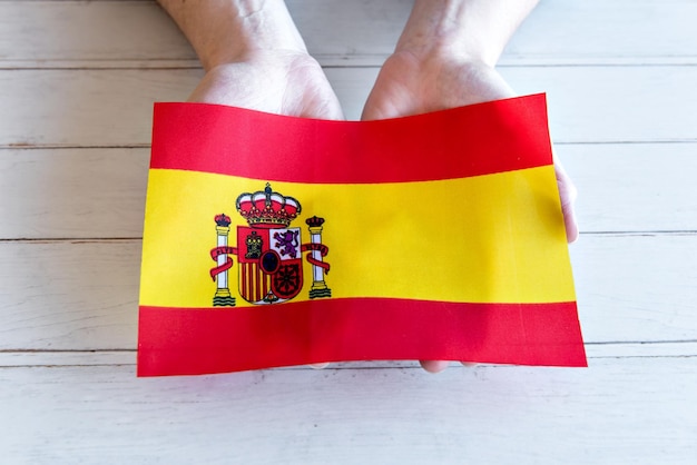 Mains tenant le drapeau de l'Espagne