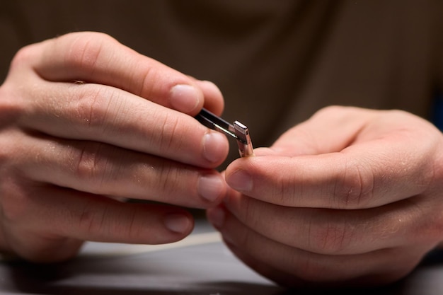 Mains tenant fermement les câbles USB et connecteurs à des fins de réparation électronique