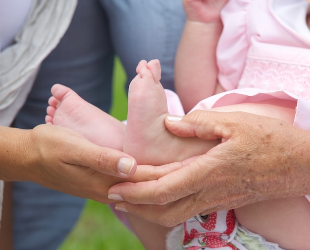 Mains tenant les petits pieds de bébé