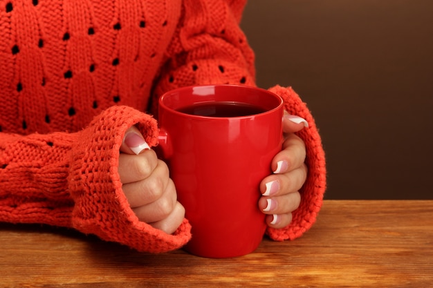 Mains tenant une tasse de boisson chaude, gros plan