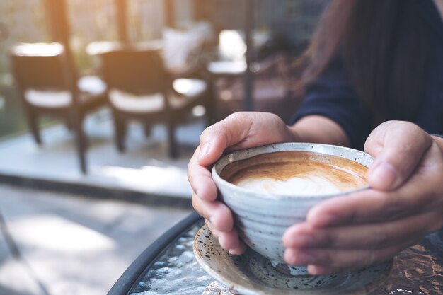 mains tenant une tasse de café