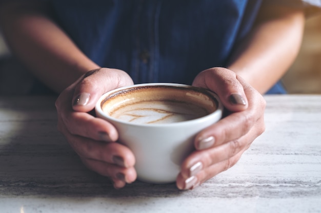 Mains tenant une tasse de café