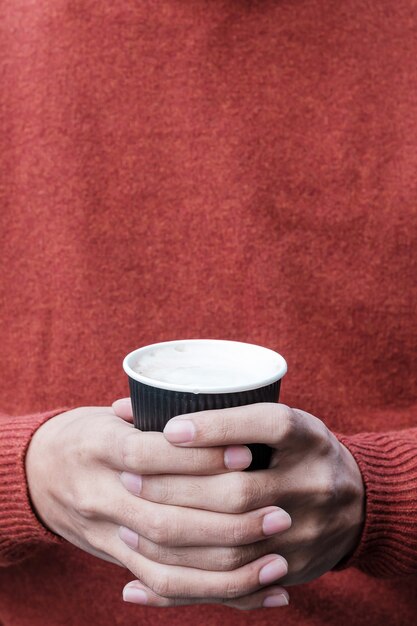 Mains tenant une tasse de papier café chaud. concept de conteneur en plastique gratuit