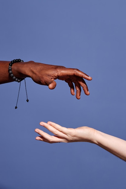 Des mains tendant vers l'extérieur sur un fond bleu solide