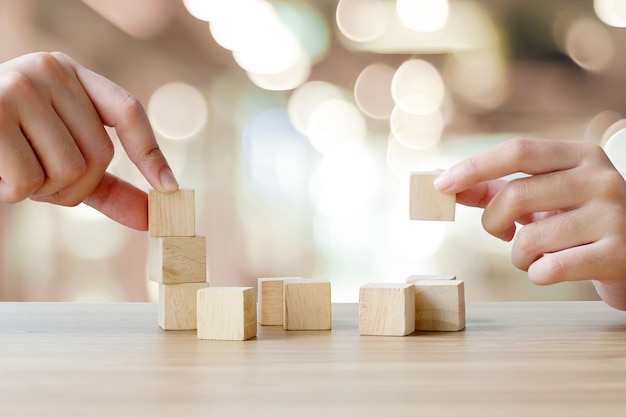 Mains, tenue, blanc, cubes en bois, sur, table, sur, flou, résumé, bokeh, lumière fond