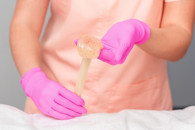 Les mains tiennent la pâte de sucre liquide.