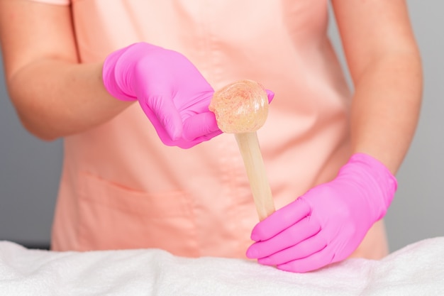 Les mains tiennent la pâte de sucre liquide.