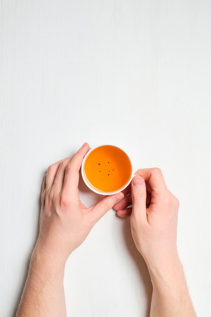 Les mains tiennent une tasse de thé frais