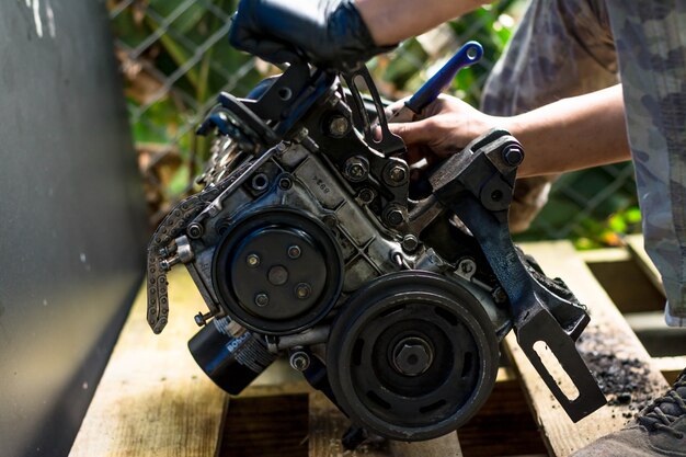 Photo mains travaillant dans un moteur de voiture. nettoyage d'un moteur de voiture. atelier mécanique