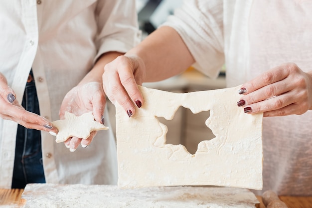 Mains travaillant avec de la pâte à préparer des cookies