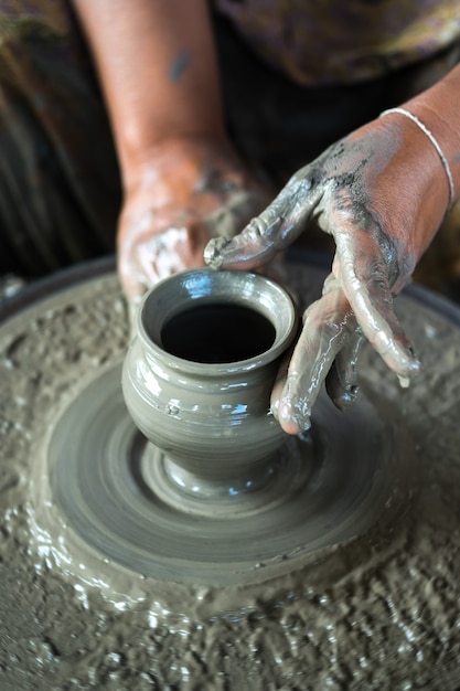 Mains travaillant sur la poterie