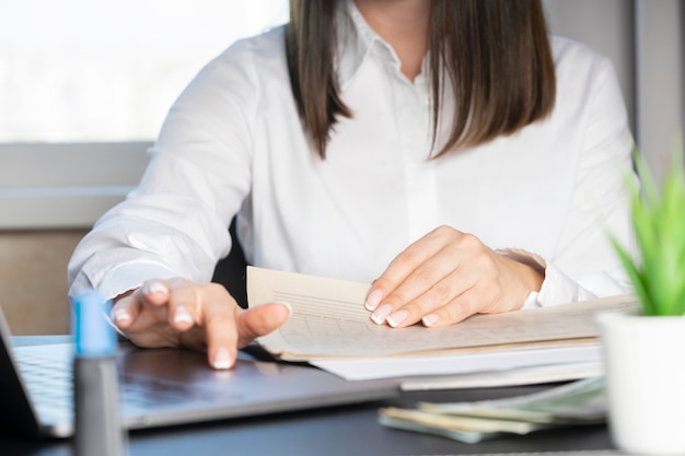 Mains d'un travailleur financier dans une chemise blanche travaillant avec des documents en gros plan.