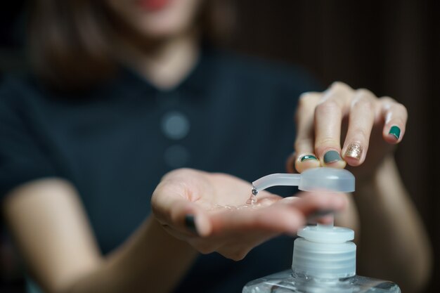 Mains en utilisant le distributeur de pompe de gel désinfectant pour les mains Désinfectant transparent dans le flacon pompe, pour tuer les germes, les bactéries et les virus.