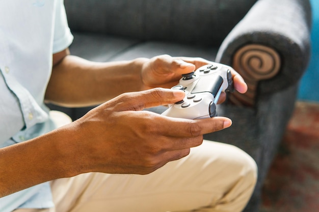 Photo mains utilisant un joystick pour jouer à un jeu vidéo à la maison