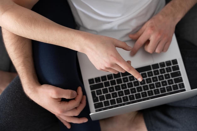 Mains utilisant un ordinateur portable et pointant vers l'écran