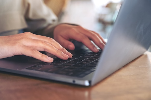 mains en utilisant et en tapant sur le clavier d'ordinateur portable sur la table