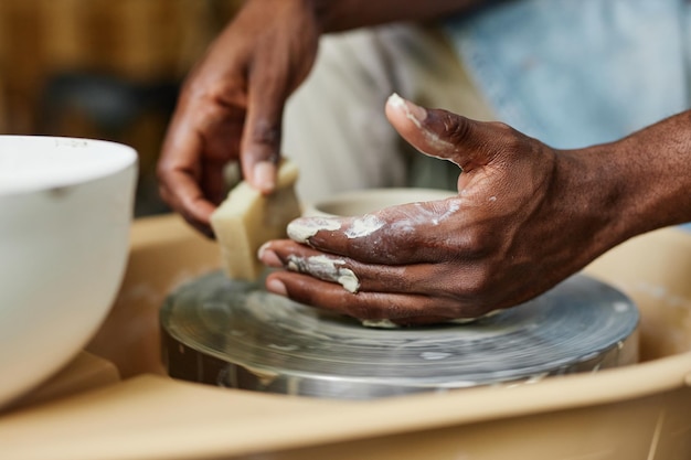 Mains utilisant un tour de potier et créant des céramiques faites à la main en classe d'art