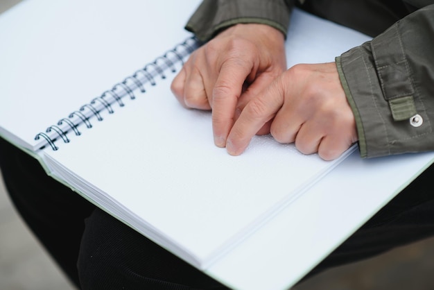 Les mains de la vieille femme lisant un livre en braille