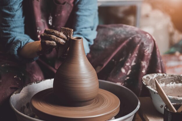 Des mains de Waman travaillant sur une roue de poterie