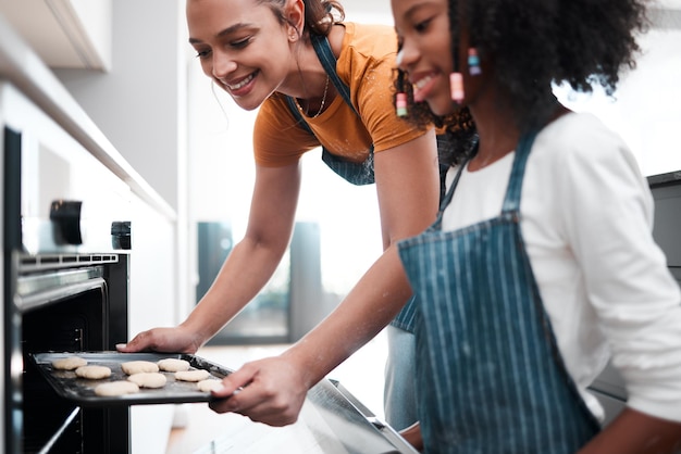 Maintenant, nous attendons qu'ils cuisent Photo d'une mère et de sa fille cuisinant ensemble dans la cuisine à la maison