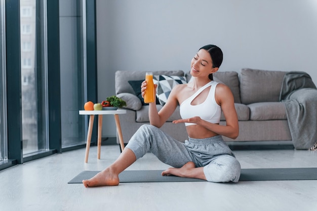 Maintient le verre avec du jus d'orange dans les mains