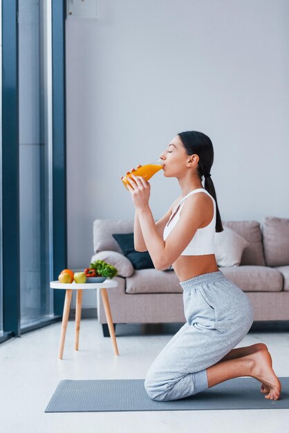 Maintient le verre avec du jus d'orange dans les mains