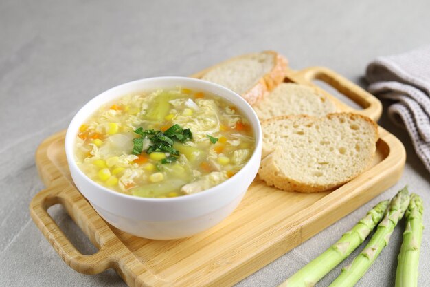 Maïs et asperges avec soupe aux œufs dans un bol blanc et pain croustillant