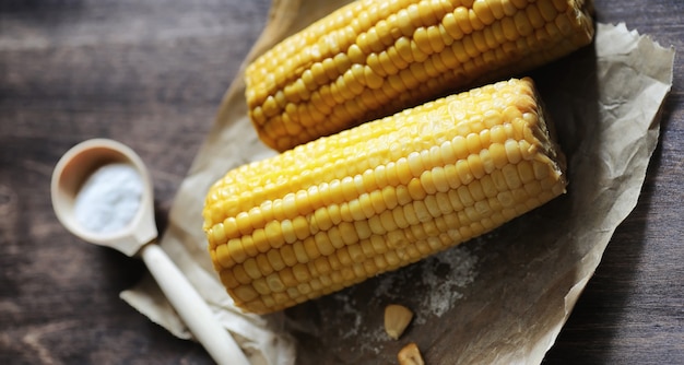 Maïs frais. Aliments naturels à partir d'épis de maïs avec du sel. Cuisine mexicaine rurale. Nourriture saine. Des épis de maïs bouillis et frits sur une table en bois sont servis avec du sel.