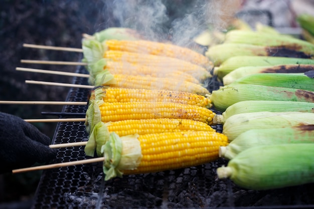 Maïs grillé sur le gril, cuisson de plusieurs maïs doré jaune brun frais