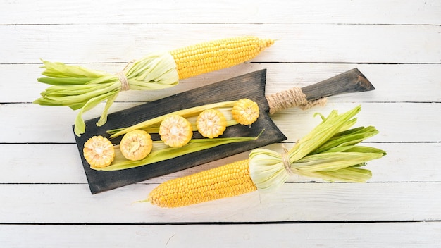 Maïs jaune frais sur une table en bois blanche Légumes Vue de dessus Espace de copie