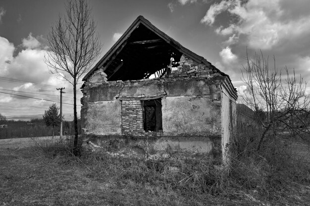 Une maison abandonnée sur un champ contre le ciel