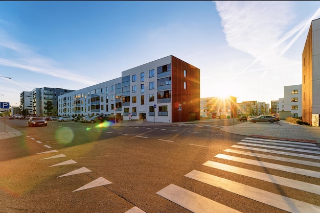 Maison d'appartements immeuble résidentiel concept immobilier complexe. Et route avec parking dans la rue. Au coucher du soleil