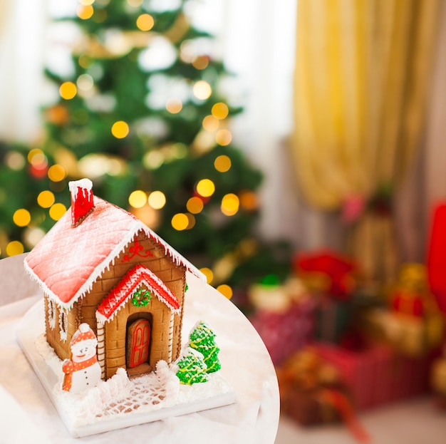 Maison de biscuits en pain d'épice dans le village de Noël sur la foire. Dessert d'arôme traditionnel de vacances avec du miel et des épices