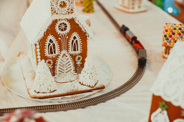 Photo maison de biscuits en pain d'épice dans le village de noël sur la foire. dessert d'arôme traditionnel de vacances avec du miel et des épices