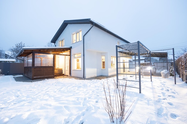 Maison blanche privée en hiver au coucher du soleil