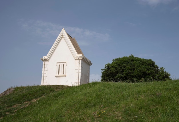 Maison blanche solitaire à côté d'un buisson