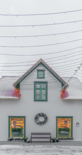 Maison en bois blanc islandais typique avec toit enneigé à Selfoss un jour nuageux brumeux avec Noël