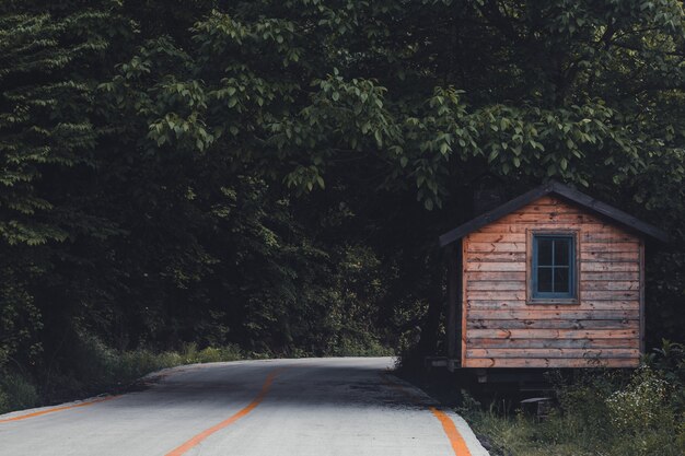 La maison en bois est dans la forêt profonde et à côté de la route