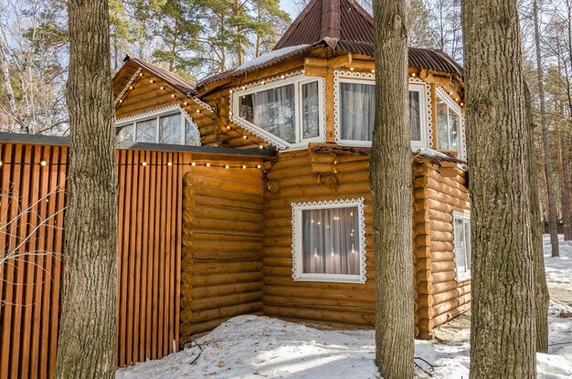 Maison en bois faite de rondins en hiver dans la forêt.