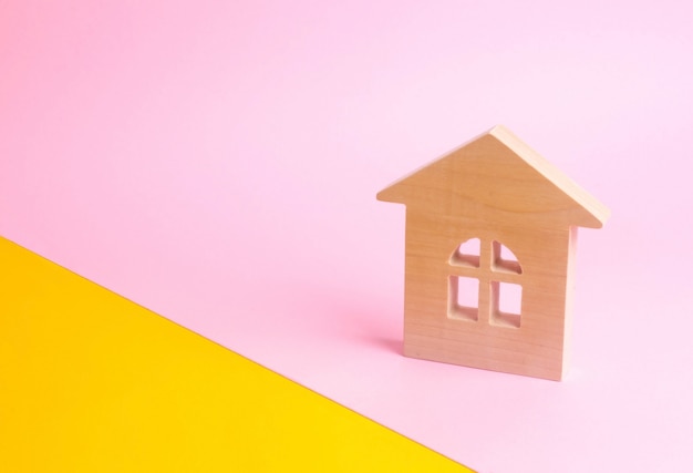 Une maison en bois sur fond rose dans un style pop