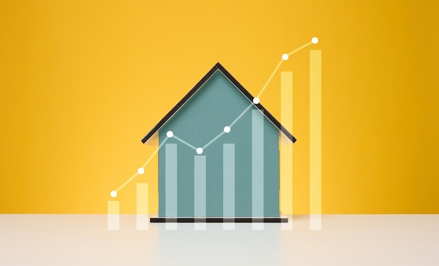 Maison en bois et un graphique avec des indicateurs croissants La hausse des prix de l'immobilier a augmenté les factures de services publics