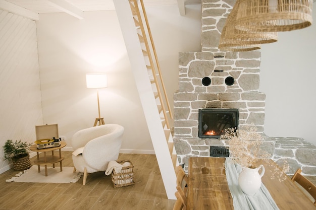 Maison en bois moderne Intérieur de style scandinave riche avec table en bois dans l'escalier du salon et cheminée
