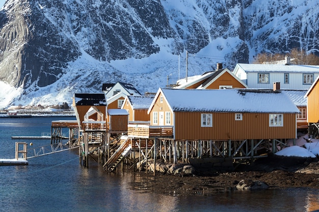 Maison en bois norvégienne traditionnelle rorbu pour se tenir sur le rivage du fjord et des montagnes au loin. Iles Lofoten. Norvège.