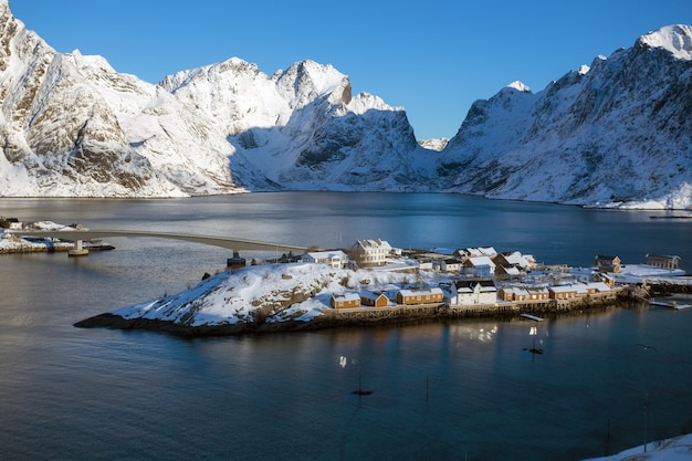 Maison en bois norvégienne traditionnelle rorbu pour se tenir sur le rivage du fjord et des montagnes au loin. Iles Lofoten. Norvège.