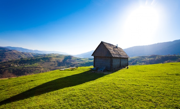 Maison en bois parmi les collines couvertes d'arbres