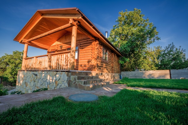 Maison en bois avec prairie devant elle