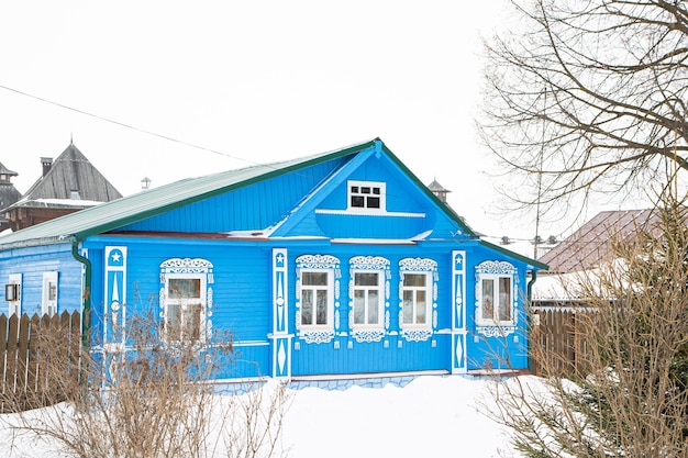 Une maison en bois russe couverte de neige