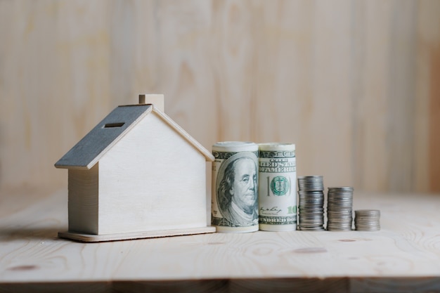 Maison en bois tirelire avec argent et pièce de monnaie